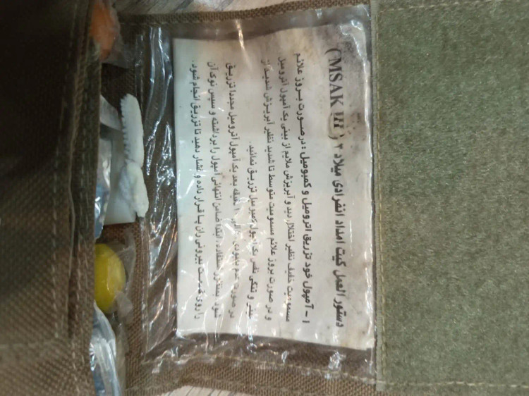 نمایش داخلی پک امداد انفرادی میلاد شامل دستورالعمل فارسی، داخل کیف پارچهای مقاوم.
